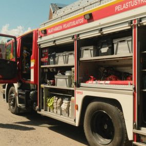 A Finnish firefighter inspects a fire truck with open compartments in Kausala, Finland.