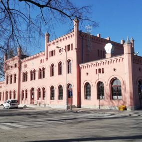 Pink historic train station with Gothic architecture in sunny Jawor, Poland.